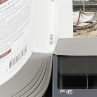 image of a book with its spine hanging off the side of the scanner so as to provide a better page scan.